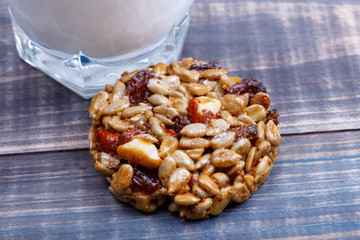Sweetness from the peeled sunflower seeds, nuts and raisins covered with sugar syrup - kozinak. Nearby is a glass of milk.
