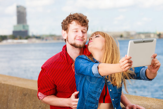 Young couple taking self picture selfie with tablet
