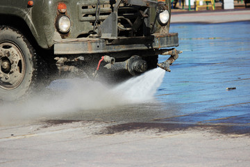 harvesting machine washes town square from dirt and debris in spring.