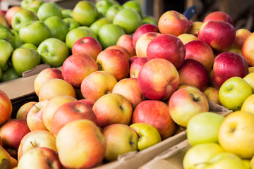 Green, red and yellow apples on the market.