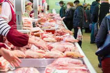 The meat Department at the market. Buyers and sellers in the market. Raw pork.