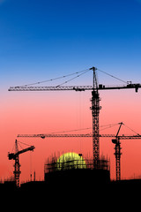Crane and building construction site at sunset