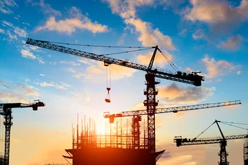 Photo sur Plexiglas construction de la ville Crane and building construction site at sunset