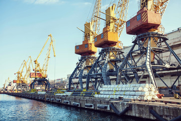 Port cargo crane over blue sky background. Sea port, crane for loading at sunset. Transportation