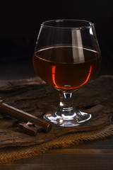 glass with cognac, whiskey and key on wooden table