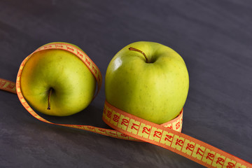 apples with measuring tape or centimeter on grey studio background