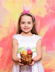 small happy baby girl holding bucket with easter eggs