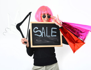 girl in wig holding package, hangers, board with sale inscription
