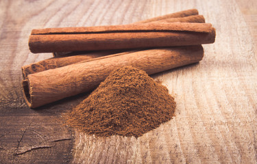 Cinnamon sticks on wooden background.