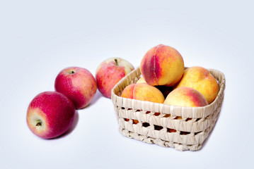 Peach fruits in a basket and apples