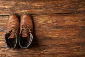 брутальніе мужские ботинки приключения  на деревянной поверхности