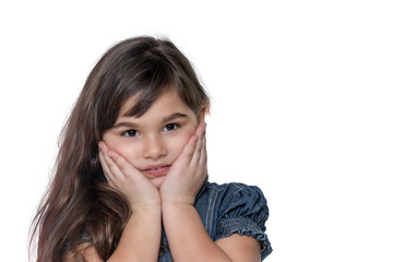 Portrait of expecting surprises brunette long haired little girl isolated on the white background. The girl is holding her face by both hands.