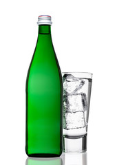 Green bottle of sparkling mineral water with glass
