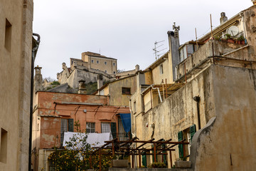 Fototapeta na wymiar San Giovanni castle looming over old houses, Finalborgo, Italy