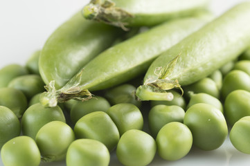 pea pods and peas on a white background largly