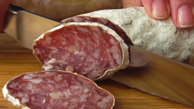 Chef cuts jerked sausage with knife