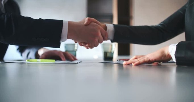Business People Signing Contracts Together Concluding Deal By Firm Handshake