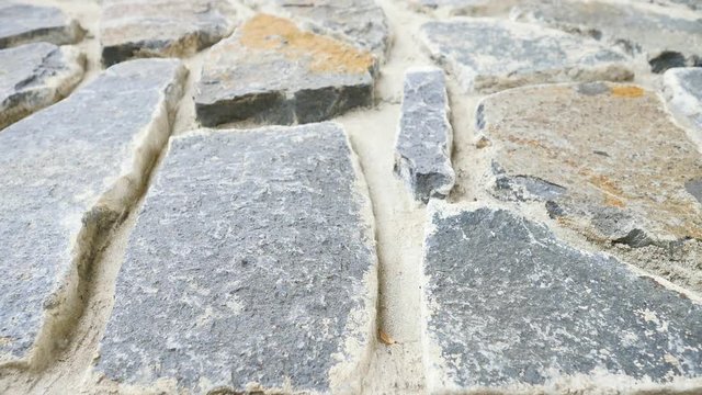 Building wall built from broken flat stones. Old stony wall from nature material and concrete, broken marl stones , traditional building materials. 