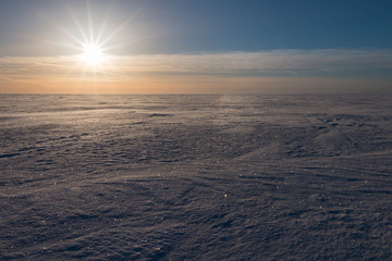Fototapeta na wymiar Low sun over frozen winter sea.