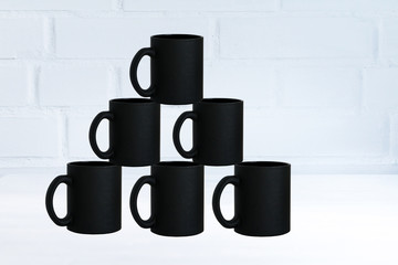 Stack of black simple form mugs. Concept of coffee, coffee break, restaurant, coffee time. Copy space.