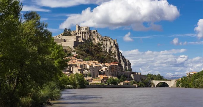 Citadel of Sisteron and Durance River with passing clouds in summer (time-lapse). Alpes de Haute Provence, Southern French Alps, France