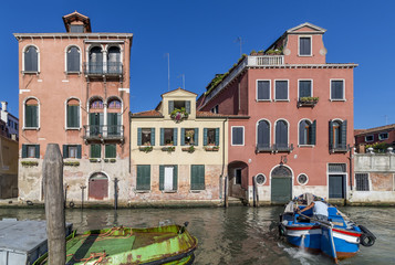 Typical Venetian houses in front of the Basilica of Santi Giovanni e Paolo, Zanipolo, with a boat in motion, Venice, Italy