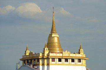 Naklejka premium Chedi of the ancient Buddhist temple Wat Sacket (Temple of the Golden Mount) against the background of a cloudy sky. Bangkok, Thailand