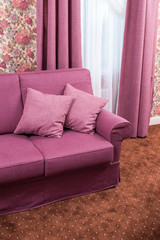 pillows on the couch on a background of curtains and tyuley