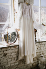 Vintage wedding dress on a brick wall with a mirror