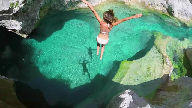 Beautiful couple diving fearless into clear blue river water on active adventure travel vacation pov 