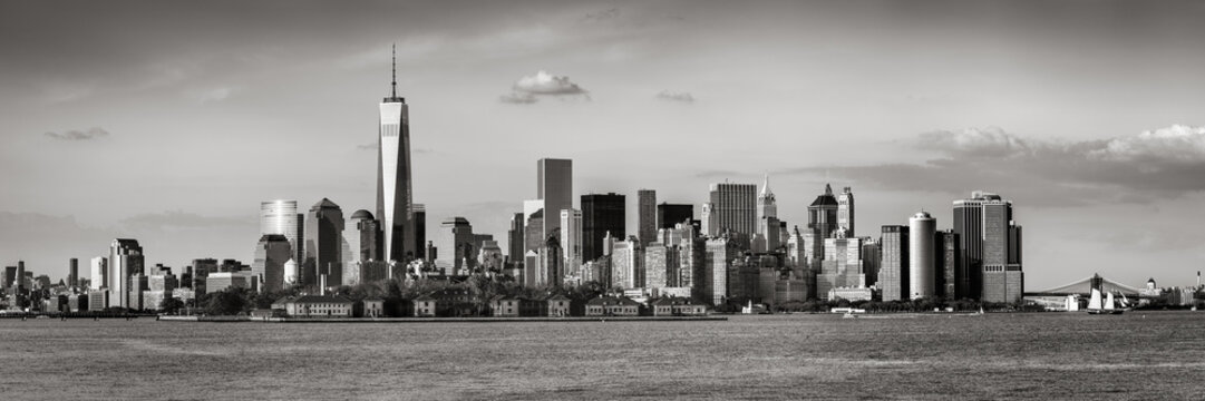 Fototapeta Lower Manhattan with the Financial District skyscrapers and Ellis Island. Panoramic view of New York City. Black & White