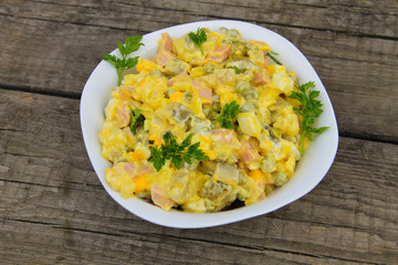 Russian traditional salad olivier on wooden table