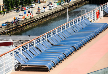 Fototapeta na wymiar Row of Blue Chairs on Deck of Ship