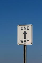 A one way sign aiming up to the sky.