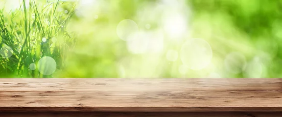 Foto auf Alu-Dibond Frühling Strahlend grüner Frühlingshintergrund mit Holztisch