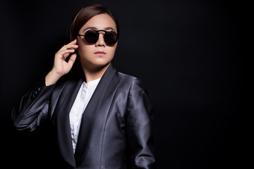 Seriously businesswoman wearing sun glasses on isolated background
