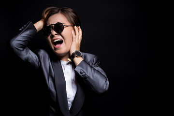 Angry woman wearing sun glasses screaming out and pulling her hair