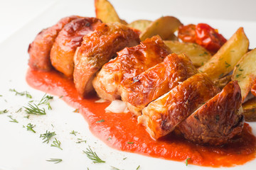 grilled chicken with a crispy crust, with BBQ sauce and baked potatoes with dill, on a white background