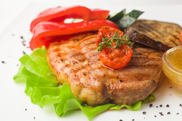 juicy grilled pork with vegetables on a white background, isolated