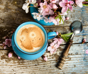 Morning coffee with pink blossom on old wood table 