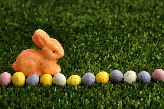 An orange bunny with a row of speckled easter eggs