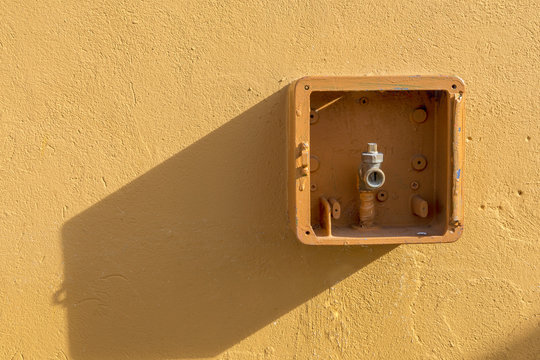 Hausanschlu&szlig;kasten an gelber Wand