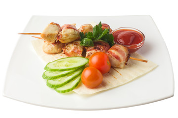 chicken on a skewer, baked in bacon, rests on a pita with cucumber, cherry tomatoes, parsley and savory sauce, white background, isolated