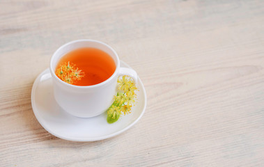 linden tea in a white cup on a light background, 