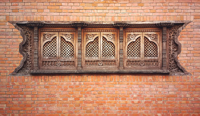 Brick wall with windows with wooden engraving in Kathmandu, Nepal