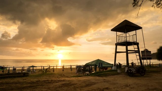 4K Time - lapse life guard tower on the beach with cloud movement and sunset .