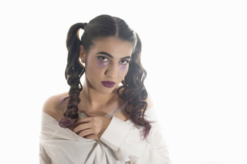 Young girl with two pony tails and artistic make up on  white  background 