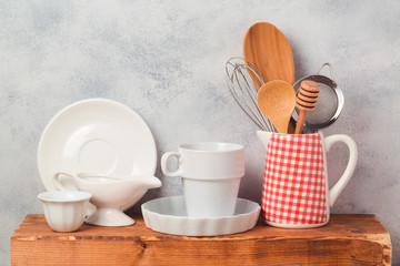Fototapeta na wymiar Kitchen utensils and tableware on wooden board over rustic background