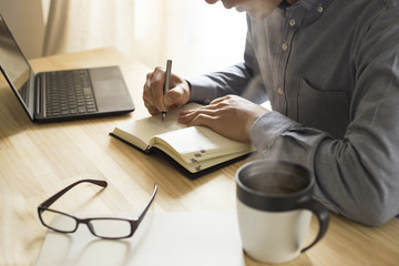 机の上で仕事・勉強をする男性
