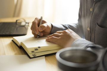 机の上で仕事・勉強をする男性